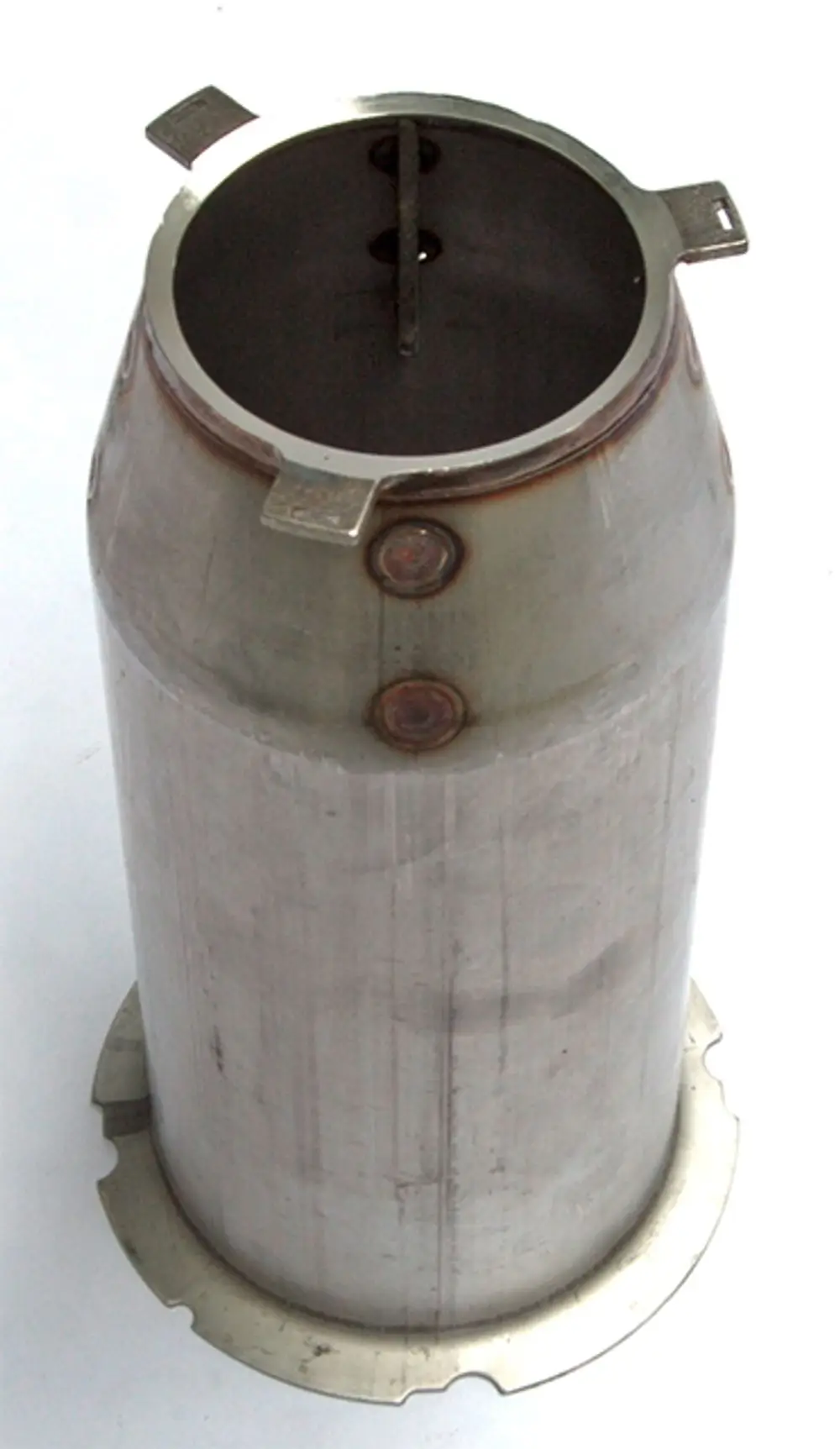Zylindrisches Metallteil mit offenem oberen Ende und zwei seitlichen Halterungen, möglicherweise für einen Heizungsbrenner von Daikin geeignet.